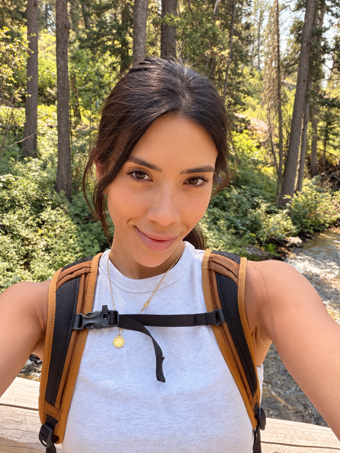 Natural outdoor portrait of Iara Reyes hiking near a forest stream